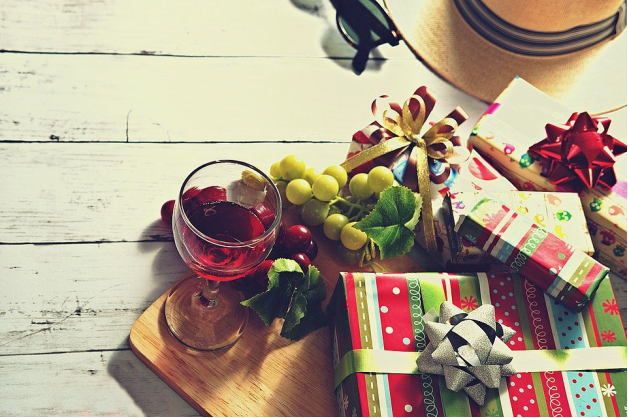 Gifts, wine, and grapes on a wooden board